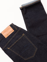 The Recco F V2 Jeans - Rinse Wash by Blue de Gênes are shown folded against a white background, with a brown branded leather patch and visible yellow stitching on the back pocket.