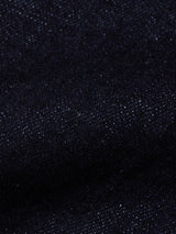 A close-up of the Recco F V2 Jeans - Rinse Wash by Blue de Gênes, showcasing dark blue denim fabric with a textured weave and fine white specks throughout.