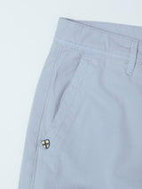 Close-up of Blue de Gênes BGmenzo Vecchio Chino in Blue Fog, highlighting the waistband, front pocket, belt loop, and a small shield-shaped logo near the pocket.