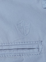 Close-up of Blue de Gênes BGmenzo Vecchio Chino in Blue Fog, highlighting the comfort stretch fabric, detailed stitching, and shield and cross emblem above a horizontal welt pocket.