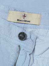 Close-up of BGmenzo Vecchio Chino - Blue Fog by Blue de Gênes, featuring an open zipper, metal button, and beige label with a red and white shield—crafted for comfort stretch and a vintage look.