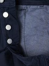 Close-up of the BGpaulo Teo Pant - Dark Navy by Blue de Gênes, showing grey pocket lining and silver shield-embossed buttons along the fly—details inspired by vintage military styles.