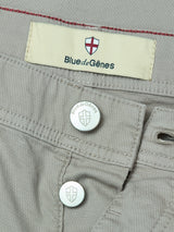 Close-up of Shadow Green BGpaulo Teo Pant by Blue de Gênes, featuring metallic buttons and a fabric label with the brand name and red-white shield emblem, inspired by vintage military pants.
