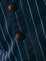Close-up of the BGlumen Toll Gilet in navy stripe by Blue de Gênes, featuring cotton fabric with thin white vertical stripes and two brown buttons.