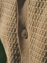 Close-up of the BGbilly S/S Cardigan in Chalk by Blue de Gênes, a vintage-inspired knit with a textured pattern and a single central plastic button.