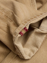 Close-up of the hem of Blue de Gênes BGgiacomo Color Jeans - Tanin, highlighting detailed stitching on rigid denim and two small red fabric tabs along the inside seam.