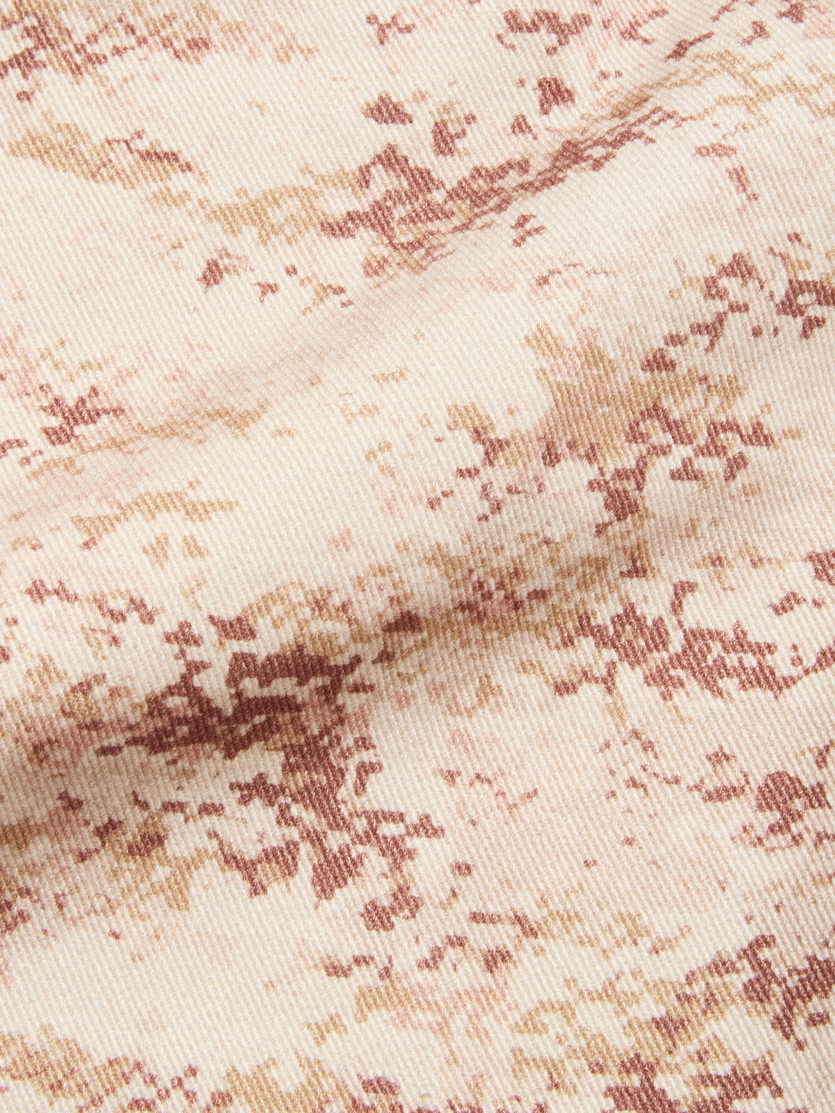 Close-up of BGcupra Print Shorts - Multi Pattern by Blue de Gênes, showing beige fabric with mottled brown and tan, visible weave, and a soft diagonal fold—highlighting comfort and casual style.