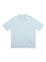 The BGjohn Slubby Polo - Blue Fog by Blue de Gênes is a light blue short-sleeve knit polo with an open placket, made from slubby cotton for vintage-inspired style, shown laid flat on a white background.