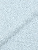 Close-up of the BGjohn Slubby Polo in Blue Fog by Blue de Gênes, featuring light gray slubby knit fabric and a visible diagonal seam that recalls vintage leisurewear and the classic comfort of a soft cotton shirt.