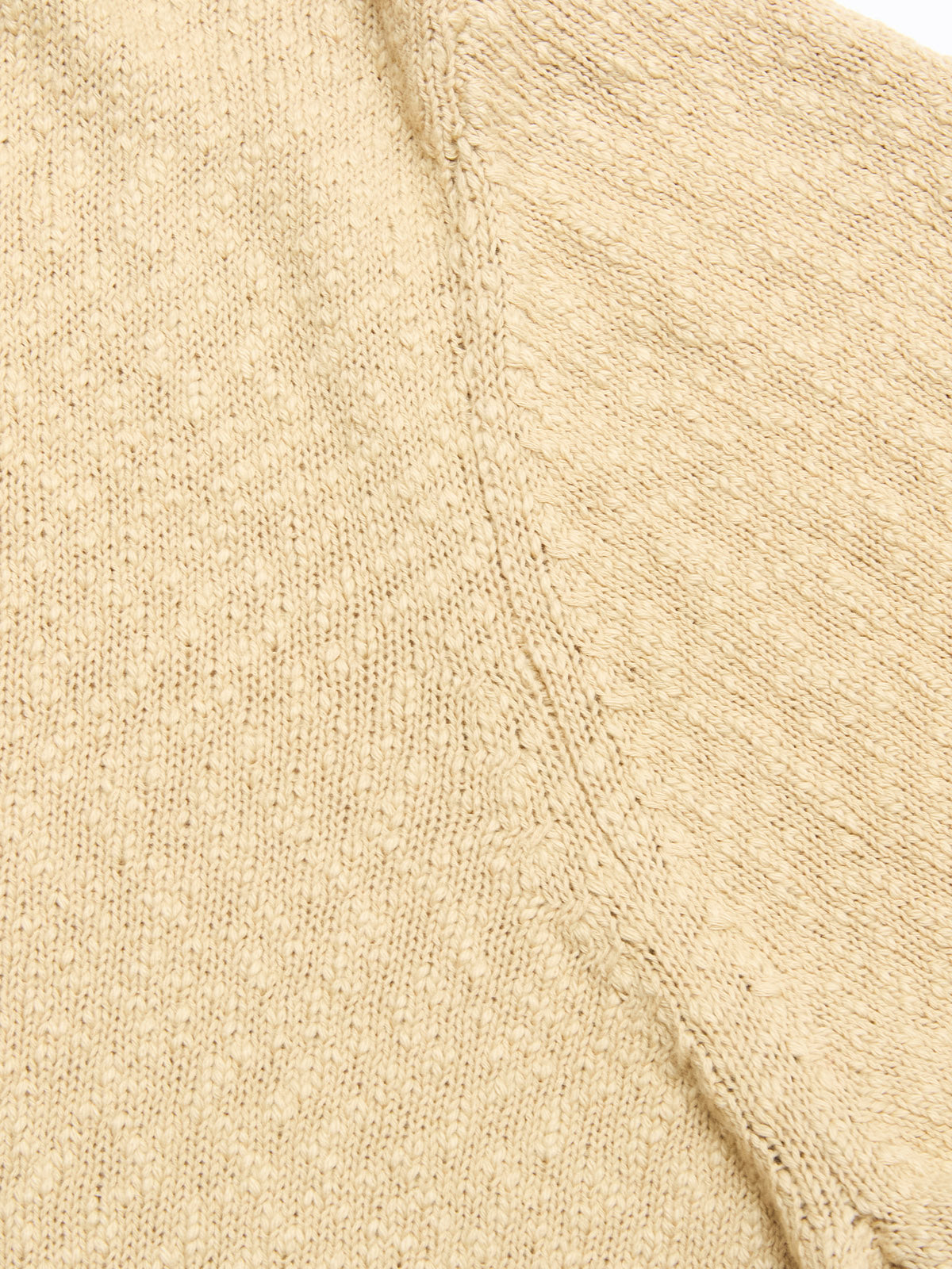 Close-up of the BGjohn Slubby Polo in Pale Khaki by Blue de Gênes, highlighting the textured beige cotton knit fabric with visible stitches and seam details.