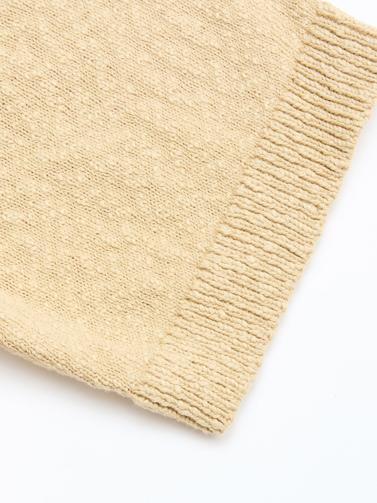 A close-up of the Blue de Gênes BGjohn Slubby Polo in Pale Khaki shows its beige slubby cotton knit fabric with a ribbed edge, set against a white background.