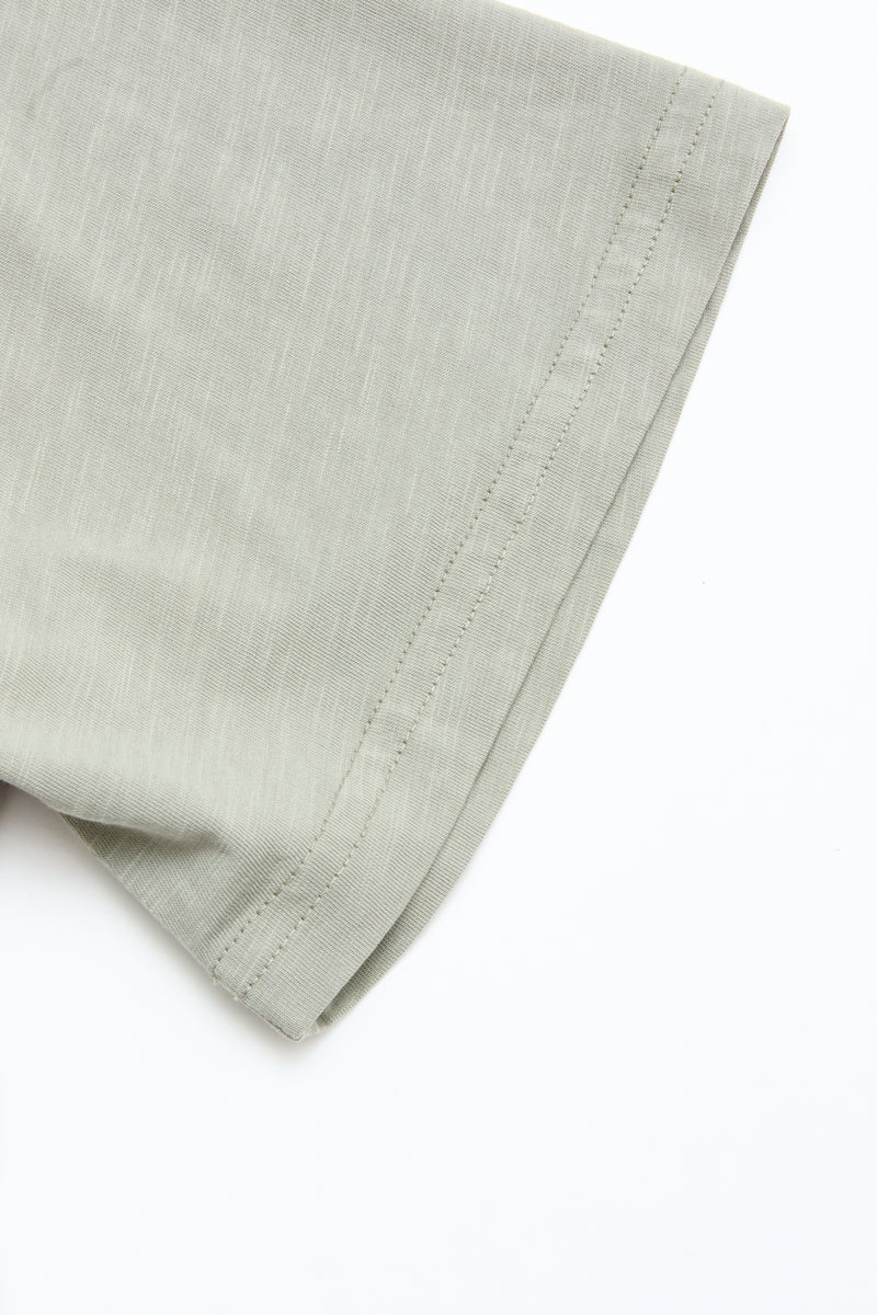 Close-up of the BGoscar T-Shirt - Shadow Green by Blue de Gênes, featuring short sleeves, 100% cotton fabric, visible stitching details, and a soft texture against a plain white background.