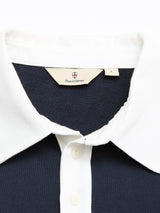A close-up of the BGclubhouse Rugby Sweatshirt - Navy by Blue de Gênes in soft cotton jersey, featuring a white collar and buttons. The Blue de Gênes label and L size tag are stitched inside the collar.