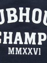 Close-up of navy BGclubhouse Rugby Sweatshirt by Blue de Gênes, showing 100% cotton fabric with white raised "UBHOUSE CHAMP MMXXVI" embroidery, part of the Clubhouse Champs Collection sportswear.