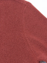Close-up of the Porto Polo Knit - Henna by Blue de Gênes, featuring textured reddish-brown wool fabric and detailed shoulder seam, showcasing the refined knit pattern and stitching of this elegant leisurewear piece.