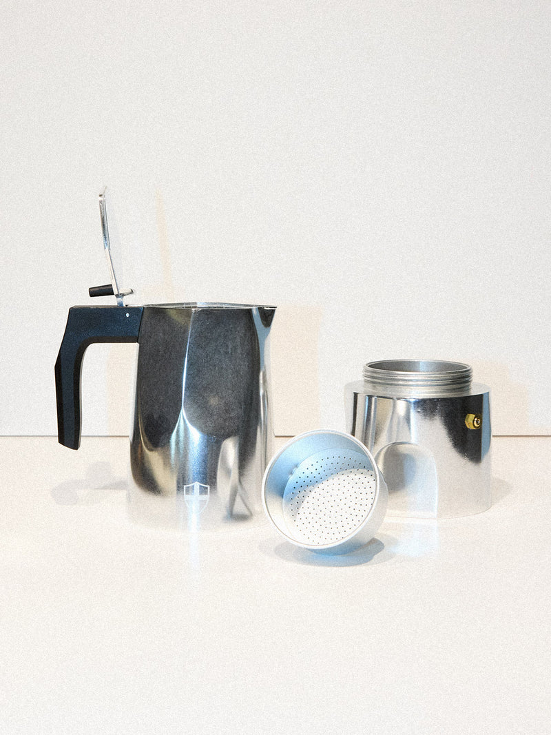 The BDG Coffee Maker - Grey by Blue de Gênes is shown disassembled into base, filter basket, and pot with black handle, arranged on a white surface against a plain background.