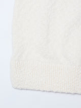 Close-up of the BGjohn Slubby Polo in Chalk by Blue de Gênes, showing ribbed detailing along the cream-colored hem against a plain white background.