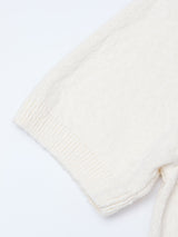 Close-up of the BGjohn Slubby Polo in Chalk by Blue de Gênes—a cream-colored, short-sleeve sweater with ribbed knit cuffs, inspired by vintage leisurewear and displayed on a white background.