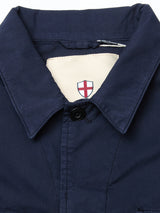 A close-up of the Blue de Gênes BGhunter Vecchio Jacket in dark navy, featuring a single black button and a beige inner tag with a red and white shield emblem.