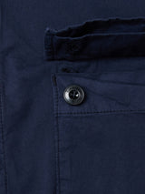 Close-up of the BGHunter Vecchio Jacket in Dark Navy by Blue de Gênes, featuring cotton stretch fabric, a black button, pocket flap, visible stitching details, and part of a buttonhole for a classic field jacket look.