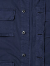 Close-up of the Blue de Gênes BGhunter Vecchio Jacket in Dark Navy, featuring black buttons, contrast buttonholes, and two large flap chest pockets. The cotton stretch fabric resembles classic field jacket canvas.