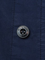 Close-up of the Bghunter Vecchio Jacket in dark navy by Blue de Gênes, featuring a metallic engraved four-hole button and vertical stitching—details that highlight the refined style of this modern cotton stretch field jacket.