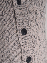 Close-up of the Blue de Gênes Sakura Knit Cardigan - Stone, a chunky wool blend cardigan in beige and gray with a ribbed button band, four black buttons, and a textured knit pattern.