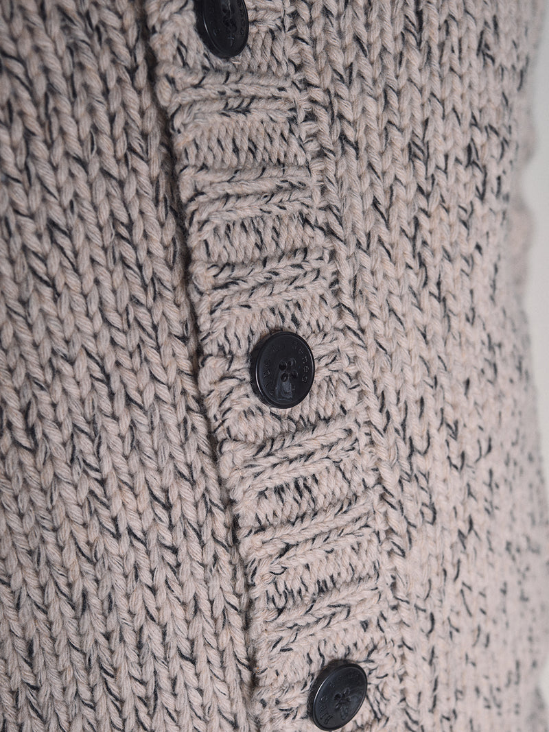 Close-up of the Blue de Gênes Sakura Knit Cardigan - Stone, a chunky wool blend cardigan in beige and gray with a ribbed button band, four black buttons, and a textured knit pattern.