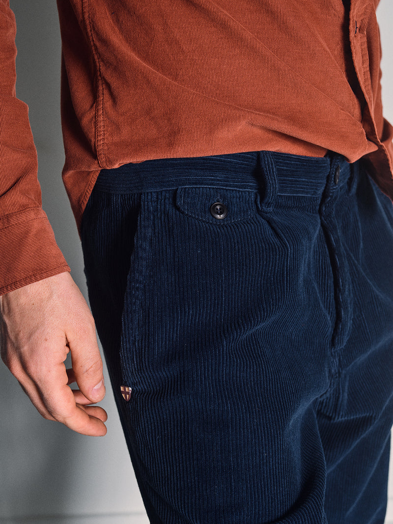 A person wears the Blue de Gênes Zamboni Velu Shirt in Henna, their left hand relaxed at their side. The photo highlights the shirt’s rich texture and color.
