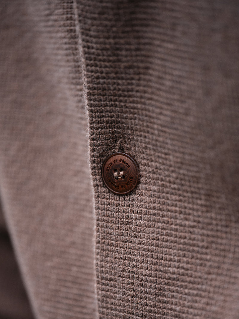 Close-up of the Gifu Knit Cardigan - Chocolate by Blue de Gênes, highlighting a textured wool blend and a round brown button with four holes—a refined detail from this premium men’s knitwear.