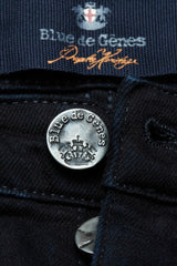 Close-up of durable black denim Repi 3325 Black Jeans by Blue de Gênes, showcasing a metal button engraved with the brand and crest, plus a fabric label featuring the Blue de Gênes name and logo.
